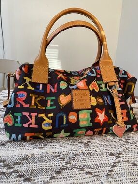 Dooney & Bourke Black Multicolor Letter Print Duffel with Tan Leather Trim
